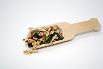 Food for rodents or birds in a wooden spoon on a white background.