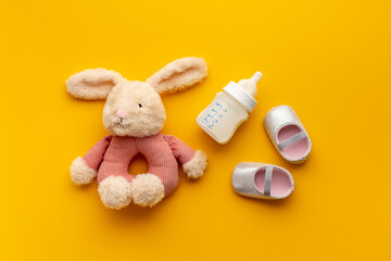 Baby girl pink shoes with milk and toy. Newborn set background