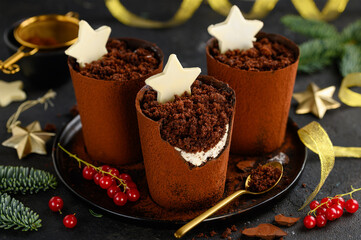 Christmas dessert  chocolate plant pots filled with cocoa biscuit crumbs and cream cheese, decorated with white chocolate stars. Festive creative dish trifle. Selective focus