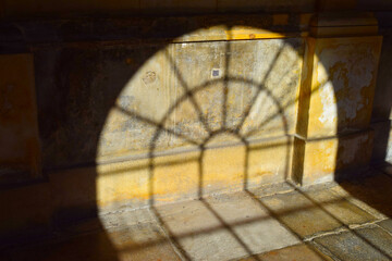Golden light falling through window of an old church in Clerkenwell, causing reflection in the stone floor in London