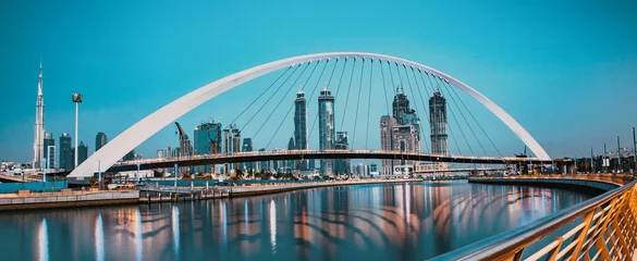 Selbstklebende Fototapeten colorful sunset over Dubai Downtown skyscrapers and the newly built Tolerance bridge as viewed from the Dubai water canal © Melinda Nagy