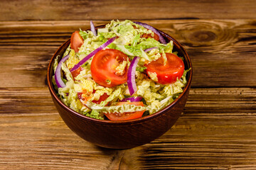 Vegan salad with savoy cabbage, tomatoes and onion in a ceramic bowl