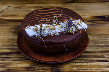 Ceramic plate with chocolate cake on a wooden table