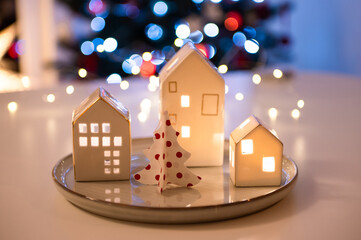 Little Scandinavian hauses, Christmas tree, and magic bokeh lights on background