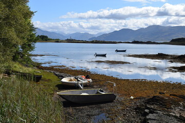 Lake in Scotland with fishing boats and mountain range