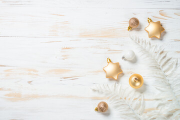 Creative layout with white and golden golden christmas decorations. Top view at white wooden table with copy space.