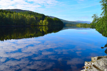 Reflection of clouds in clear waters of a Scottish lake in the Scottish Highlands