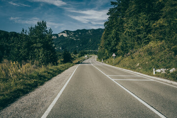 Fototapeta premium landscape with a road between mountains and meadows