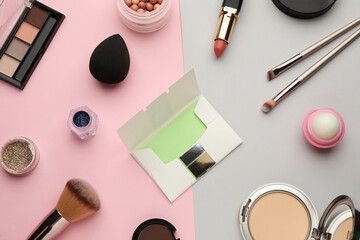 Flat lay composition with facial oil blotting tissues and makeup products on color background. Mattifying wipes