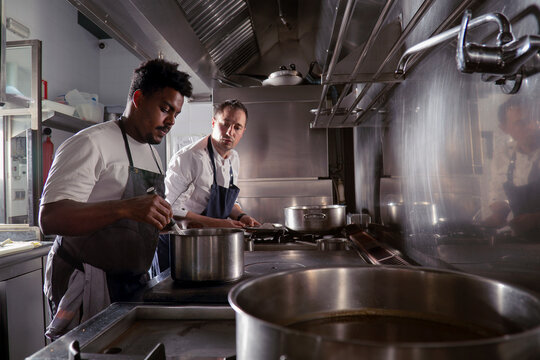 Diverse men cooking at stove in kitchen - Powered by Adobe