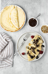 Pancakes with chocolate and nuts on a gray background, top view