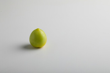 green tomato on white background.