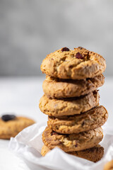 Fototapeta na wymiar Stack of oatmeal cookies with raisins, hero view, healthy cookies, dieting concept, vertical