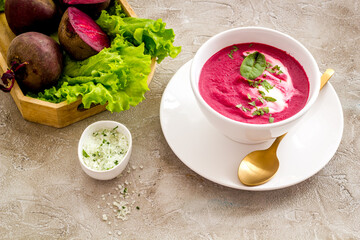 Homemade summer beet soup with raw beet roots and green leaves
