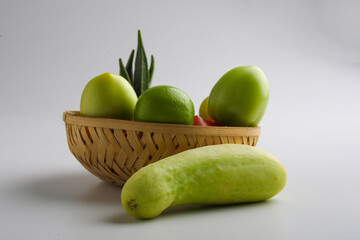 Raw vegetable in wooden bowl on white background.