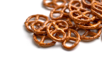 Crispy salty pretzels lie scattered on a white background. Top view. Concept: quick snack, food photography, holidays and vacations, cafes and bistros, Christmas food.