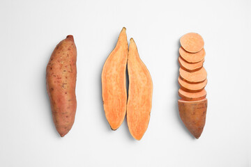 Cut and whole sweet potatoes on white background, top view