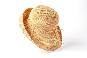 Beautiful straw hat, beautiful with a ribbon and bow on the beach hat, white background.Concept of fashion clothing accessories and beach holidays.Texture of summer straw hat from interwoven raffia.