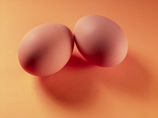 two whole eggs on a cream color surface