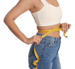 Woman measuring waist with tape on white background, closeup