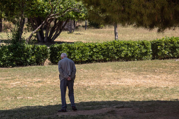 An elderly man walking at the park