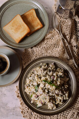 Homemade salad with dandelion leaves, coffee, coffee maker, crochet napkin.