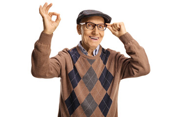 Smiling elderly man holding his glasses and gesturing ok sign