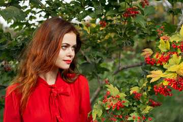 Naklejka premium woman in red shirt near bush berries nature summer