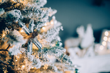 Beautiful snowy Christmas tree against blue background with beautiful ornaments for the holidays. 