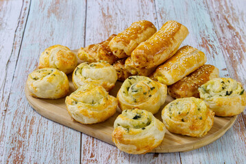 Pies and buns on a wooden table. Fresh pastries are prepared at home. A delicious crispy appetizers. close up