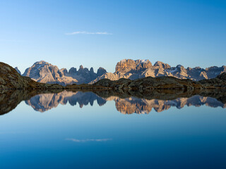 Fototapeta premium The summits of Brenta mountain range are reflected in Lago Nero. Brenta group in the Dolomites, part of UNESCO. Europe, Italy, Val Rendena