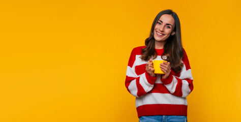 Banner photo of cute happy young brunette woman with yellow cup of hot tea or coffee in hands...