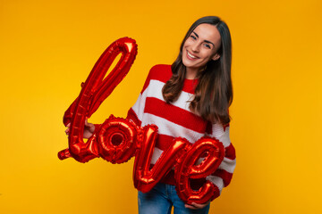 Close up photo of attractive happy brunette woman with balloons in shape word of 