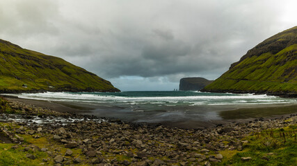 Obraz premium Europe, Faroe Islands. View during a storm of Eidiskollur and the twin stacks of Risin og Kellingin from the village of Tjornuvík on Streymoy Island.