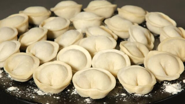 Meat dumplings on wooden black board rotating, close up