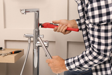 Man installing water tap in bathroom, closeup