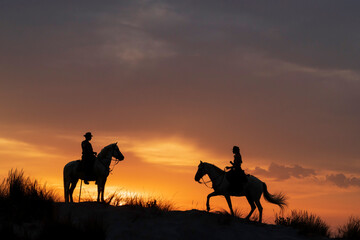 Fototapeta na wymiar Europe, France, Provence. Silhouette of Camargue horses with guardian riders at sunrise.