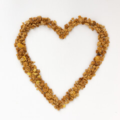 heart of crunchy granola on white background, top view