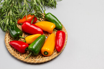 Multi-colored peppers on a wicker plate.