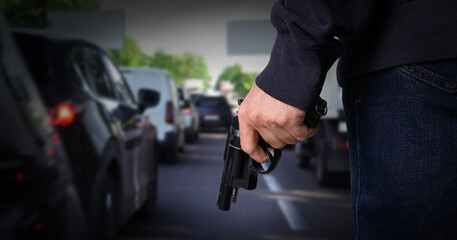 Man with gun near cars outdoors, closeup