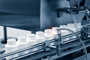 pharmaceutical industry, medicine pills are filling in the  bottle on production line machine...