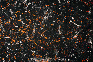 Abstract textured painted dark gray background with orange and white inclusions