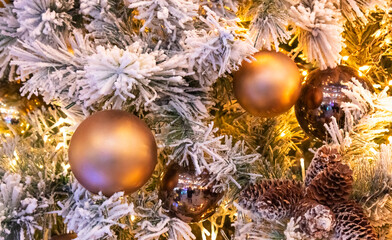 Obraz na płótnie Canvas Fir branch with balls and festive lights on the Christmas backgroundd with sparkles.
