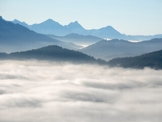 Obraz premium View from Mount Hoernle over a sea of fog hiding the valley of river Ammer towards Fuessen. Bavarian alps near Unterammergau in the Werdenfelser Land (Werdenfels county). Europe, Germany, Bavaria