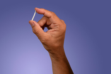 hand in rubber gloves holding a hormonal implant.