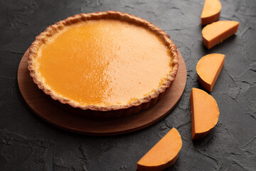 Pumpkin pie on dark background with squash slices