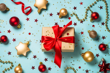 Christmas present box with holiday decorations. Flat lay image on blue.