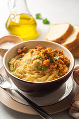 Yellow pea puree or porridge or pudding with meat sauce in bowl on concrete background