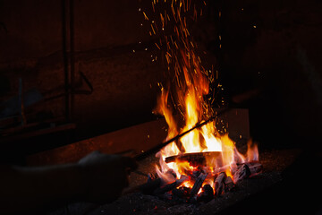 Unrecognizable Hands of Smith Preparing Metal on Anvil for Forging with spark fireworks