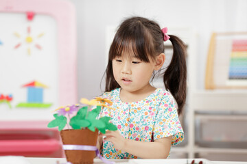 young girl making flower pot craft for home schooling